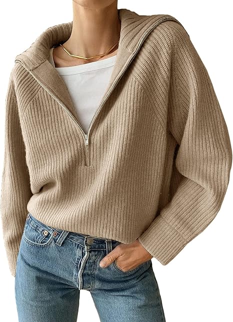 Femme portant un pull beige à col zippé, manches longues, avec un t-shirt blanc et un jean bleu. Mode automne, style décontracté et élégant.