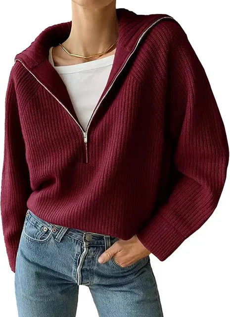 Femme portant un pull bordeaux à col zippé, manches longues, sur un t-shirt blanc, avec un jean bleu. Mode automne-hiver, style décontracté.