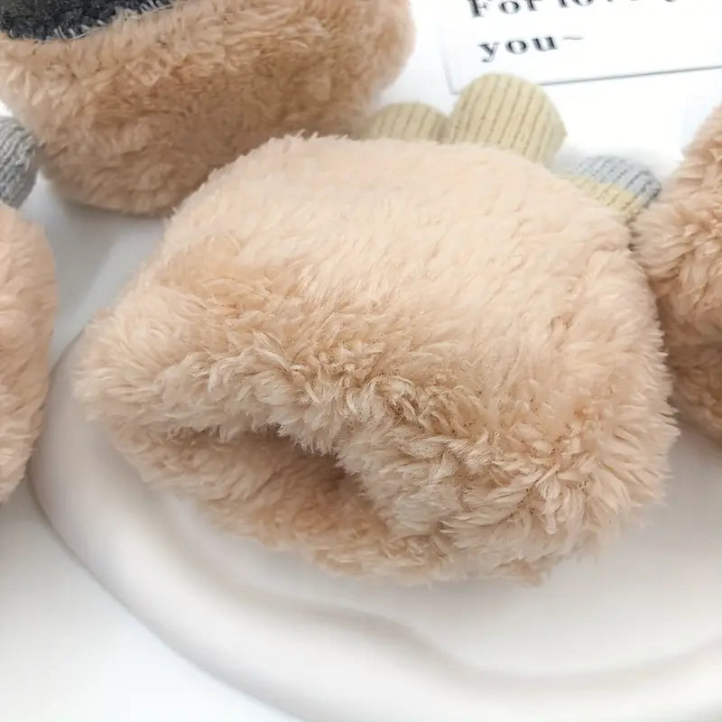 Gant en peluche beige doux, idéal pour l'hiver, posé sur une surface blanche. Accessoire chaud et confortable pour les mains.