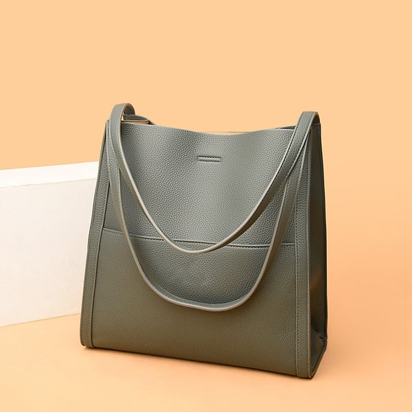 Sac à main en cuir gris élégant sur fond beige, design moderne et minimaliste, parfait pour la mode féminine et les accessoires tendance.
