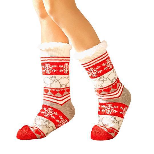 Chaussettes de Noël rouges et blanches avec motifs flocons de neige et rennes, portées sur pieds, confortables et chaudes pour l'hiver.