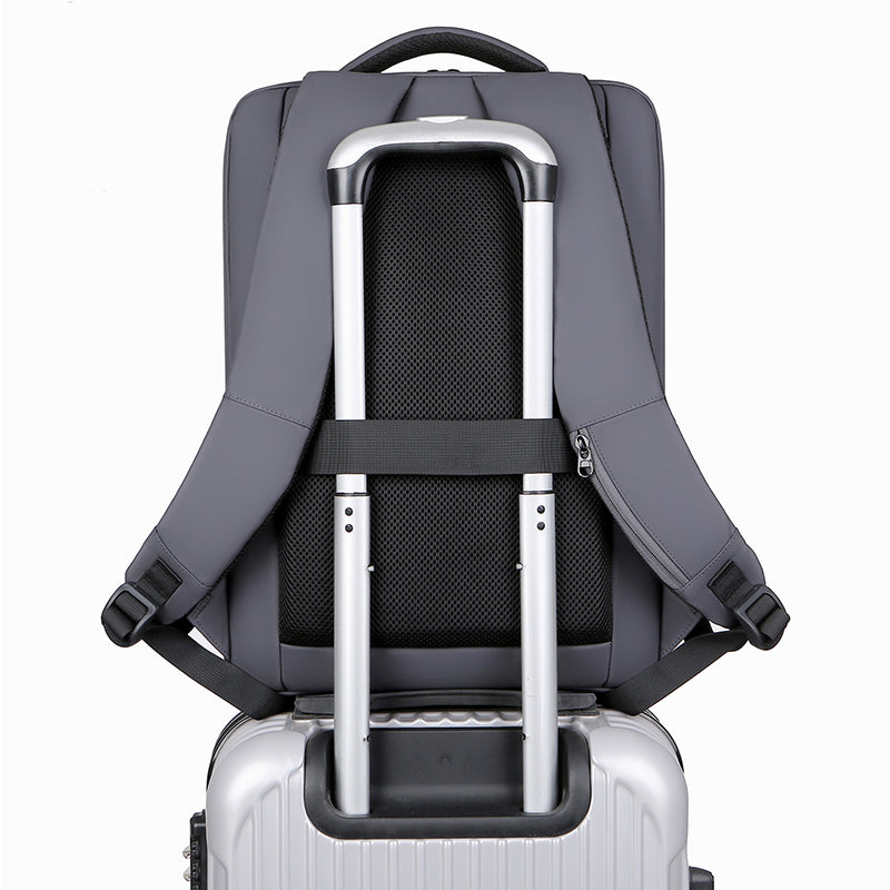 Sac à dos gris sur valise argentée avec poignée télescopique, design moderne et pratique pour voyage, transport facile, bagage à main.