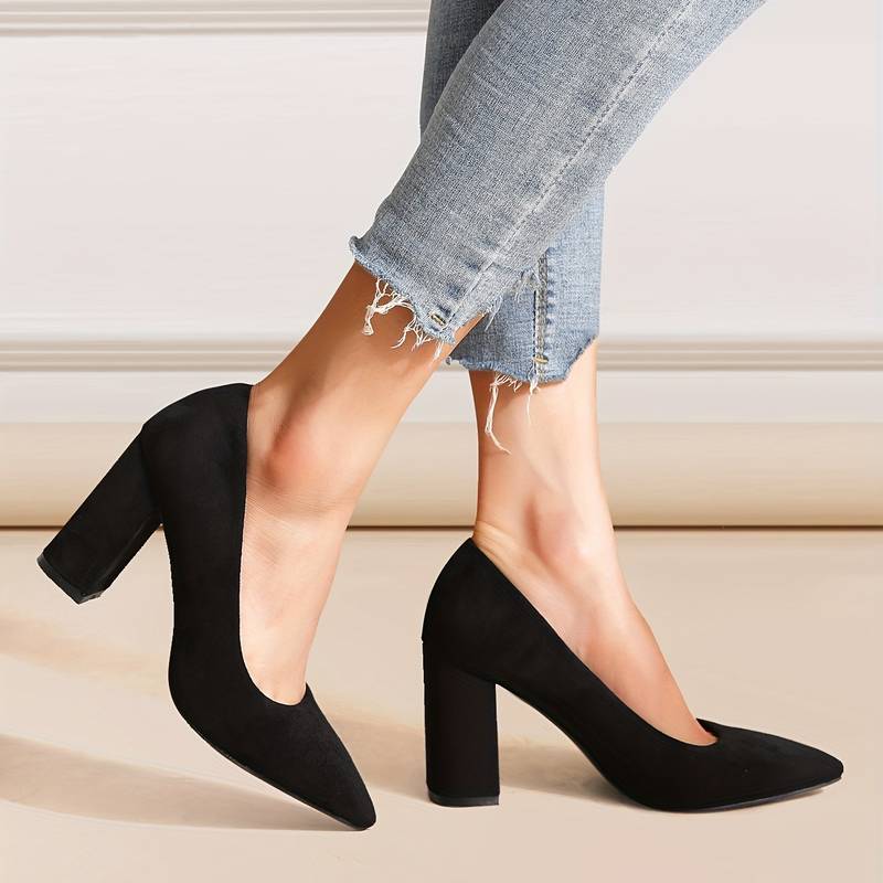 Escarpins noirs en daim à talons blocs portés avec un jean déchiré. Chaussures élégantes pour femmes, mode automne, style chic et moderne.