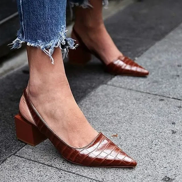Chaussures à talons carrés en cuir marron texturé, portées avec un jean effiloché. Mode urbaine élégante, tendance chaussures femme.