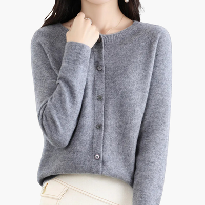 Femme portant un cardigan gris en cachemire, manches longues, col rond, boutons, style élégant et décontracté, mode automne-hiver.