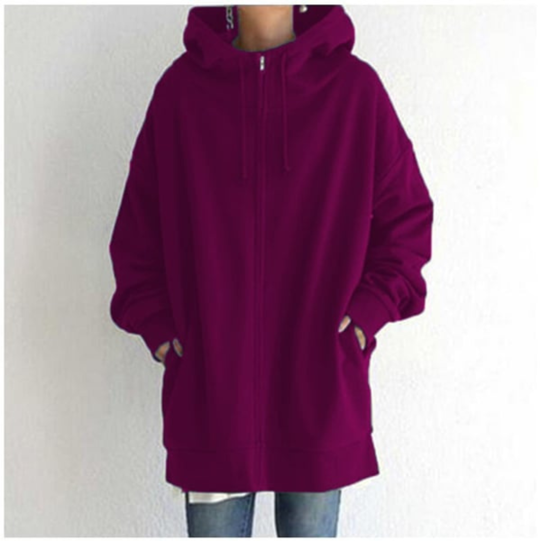 Hoodie bordeaux ample avec capuche, poches avant, porté par une personne debout. Mode décontractée, tendance automne-hiver, style urbain.