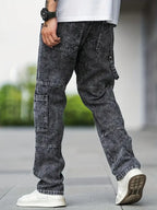 Jeans cargo gris foncé pour homme, style décontracté, avec poches multiples, portés avec des baskets blanches, mode urbaine moderne.