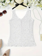 Débardeur blanc à paillettes, élégant et chic, posé à plat avec accessoires d'été : lunettes de soleil, chapeau, fleurs blanches, chaussures beiges.