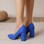 Escarpins bleus à talons hauts portés sur tapis beige, mode féminine élégante, chaussures tendance, vue arrière, style moderne.