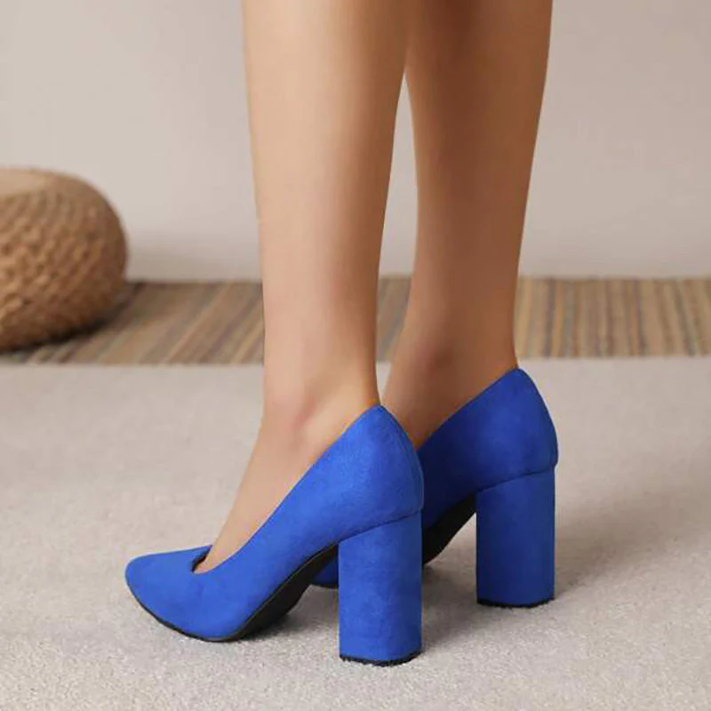 Escarpins bleus à talons hauts portés sur tapis beige, mode féminine élégante, chaussures tendance, vue arrière, style moderne.