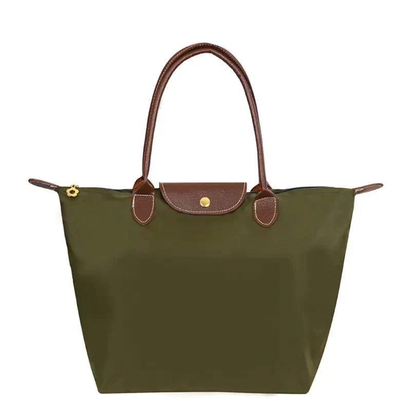 Sac à main en toile kaki avec anses en cuir marron, design élégant et pratique, idéal pour le quotidien. Accessoire mode femme tendance.