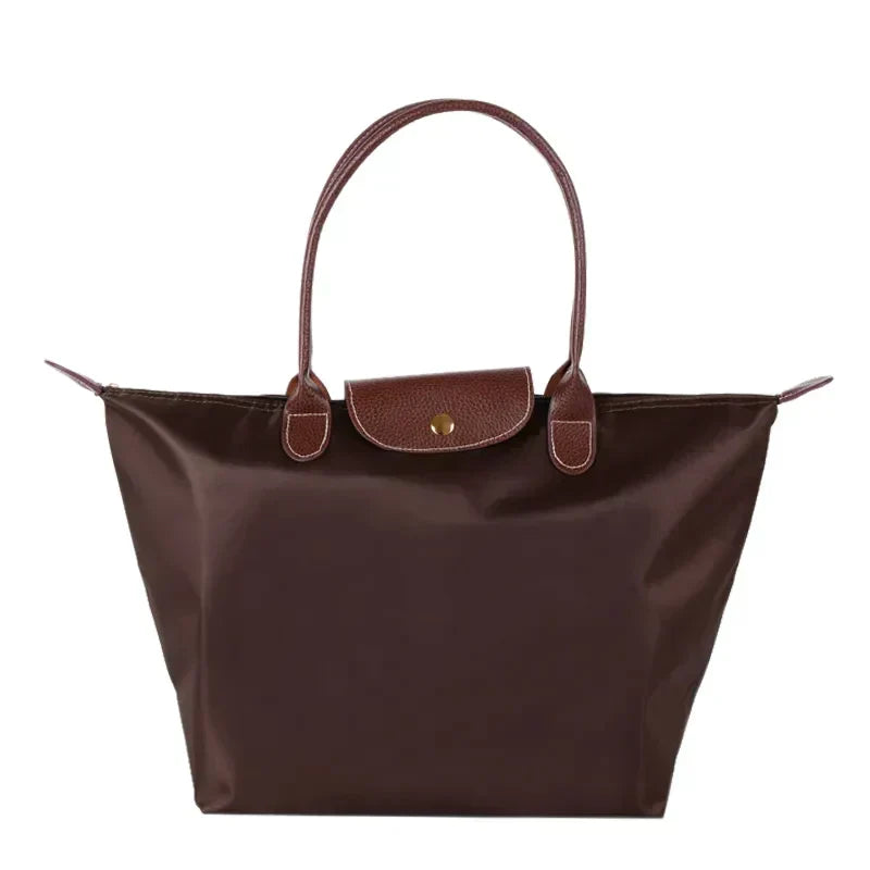 Sac à main en cuir marron, élégant et spacieux, avec poignées robustes et fermeture à bouton-pression. Accessoire mode femme tendance.