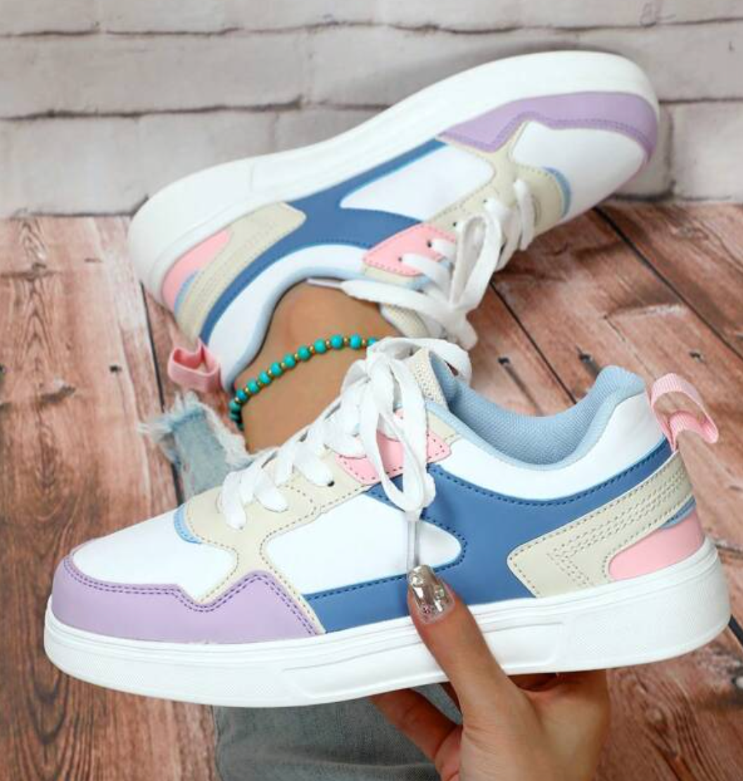 Baskets tendance multicolores pour femmes sur fond bois, avec détails pastel rose, bleu et beige. Chaussures mode décontractée, style urbain.