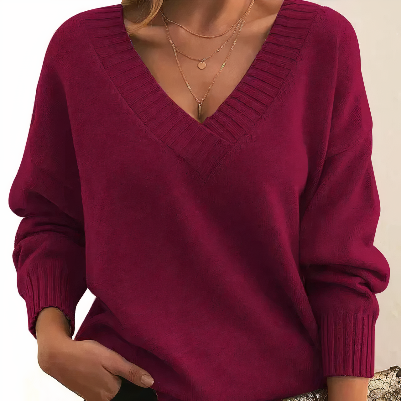Pull-over femme rouge bordeaux à col en V, manches longues, porté avec un collier doré. Mode automne-hiver, style décontracté et élégant.