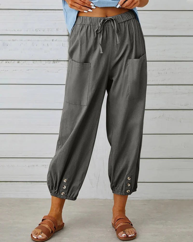 Pantalon ample gris pour femme avec poches avant, boutons décoratifs aux chevilles, style décontracté, idéal pour l'été.