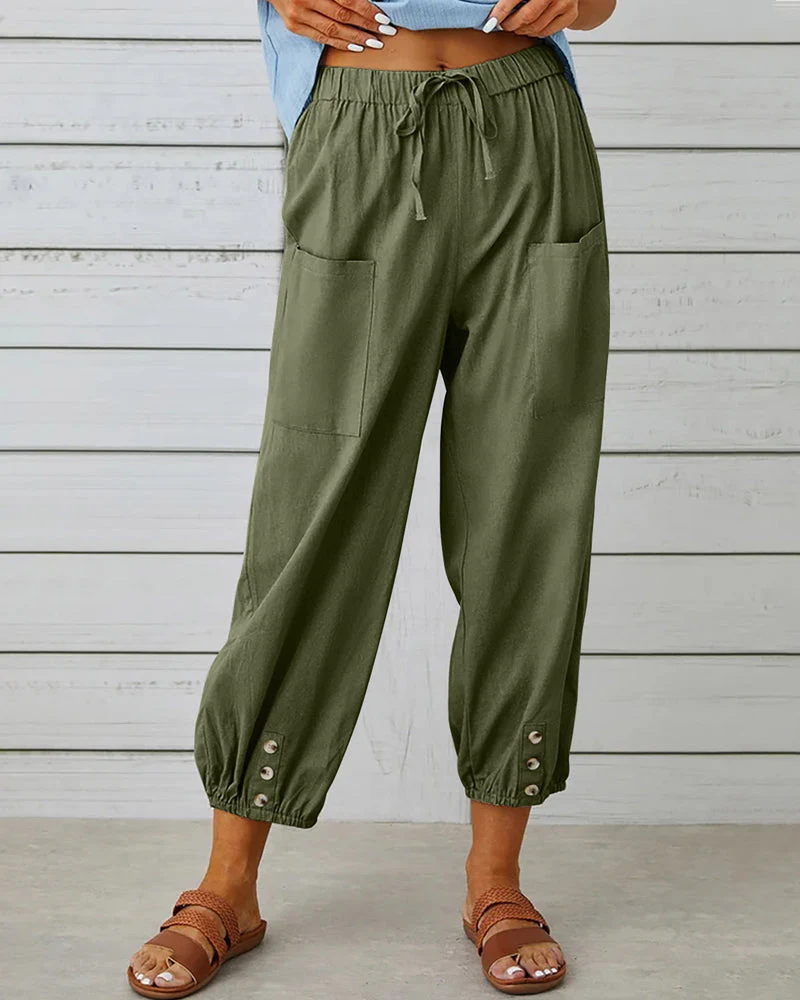 Pantalon cargo vert kaki pour femme avec poches avant, taille élastique et boutons décoratifs, porté avec des sandales marron. Mode décontractée.