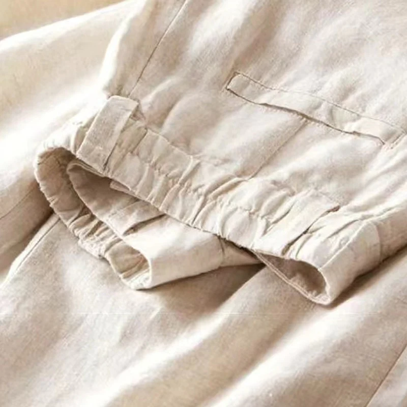 Pantalon en lin beige avec taille élastique et poche avant. Tissu léger et respirant, idéal pour l'été. Mode décontractée et élégante.