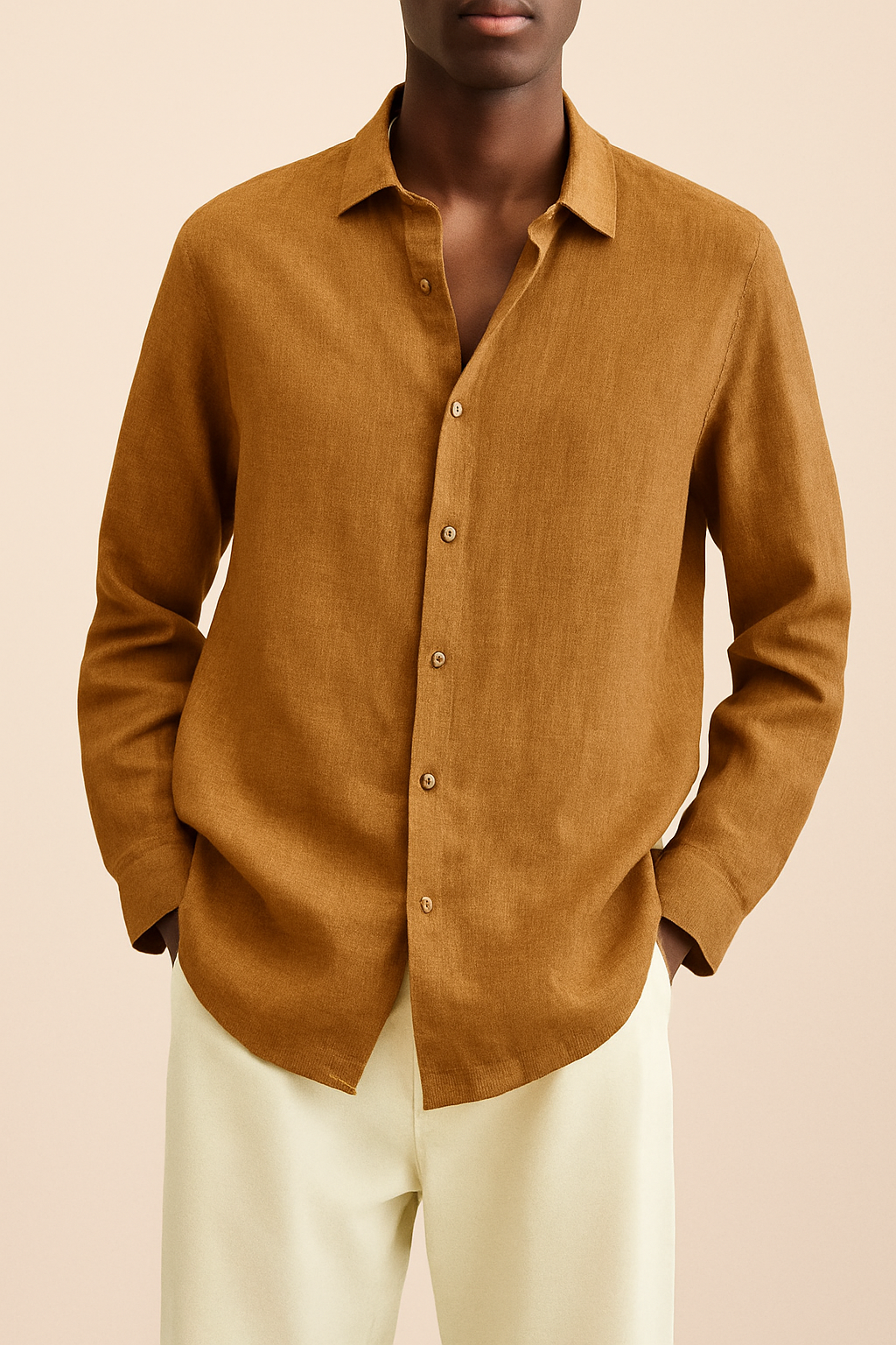 Chemise en lin marron pour homme, manches longues, col classique, boutons assortis, portée avec un pantalon beige. Mode masculine élégante et décontractée.