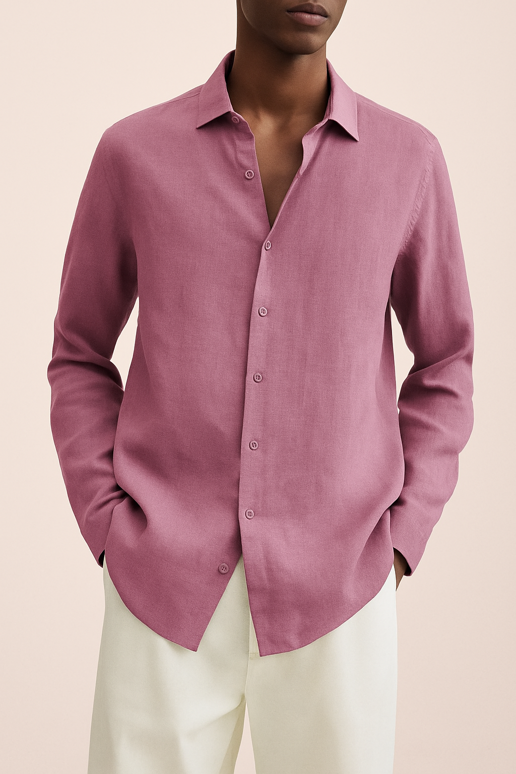 Chemise rose en lin pour homme, manches longues, col classique, portée avec un pantalon blanc. Mode masculine élégante et décontractée.