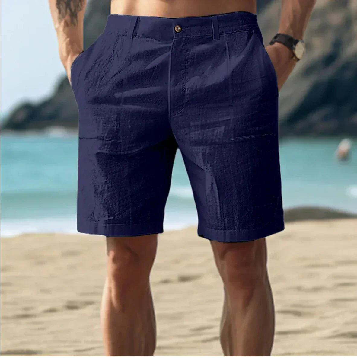 Short bleu marine pour homme sur plage, style décontracté, idéal pour l'été. Tissu léger, poches latérales, parfait pour vacances en bord de mer.
