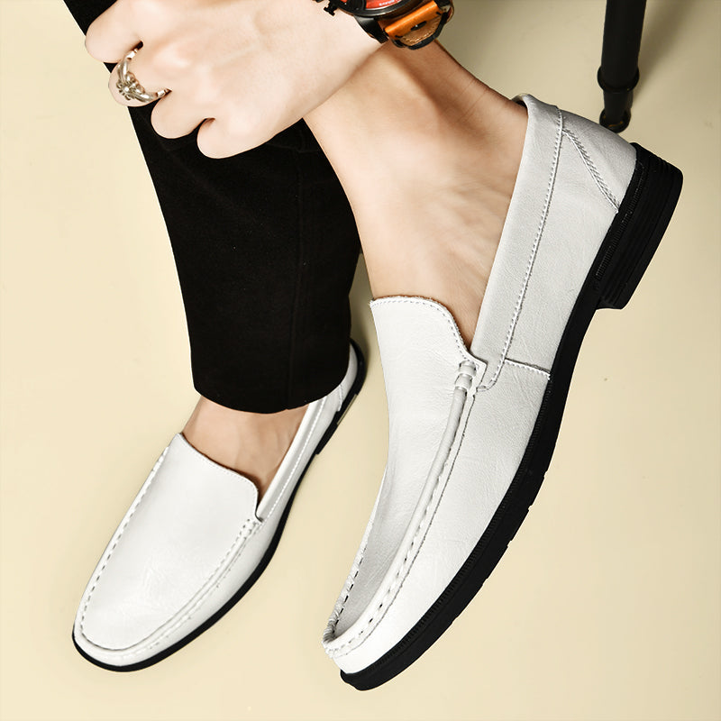 Mocassins blancs en cuir pour homme, élégants et confortables, portés avec un pantalon noir. Chaussures tendance pour un style chic et moderne.