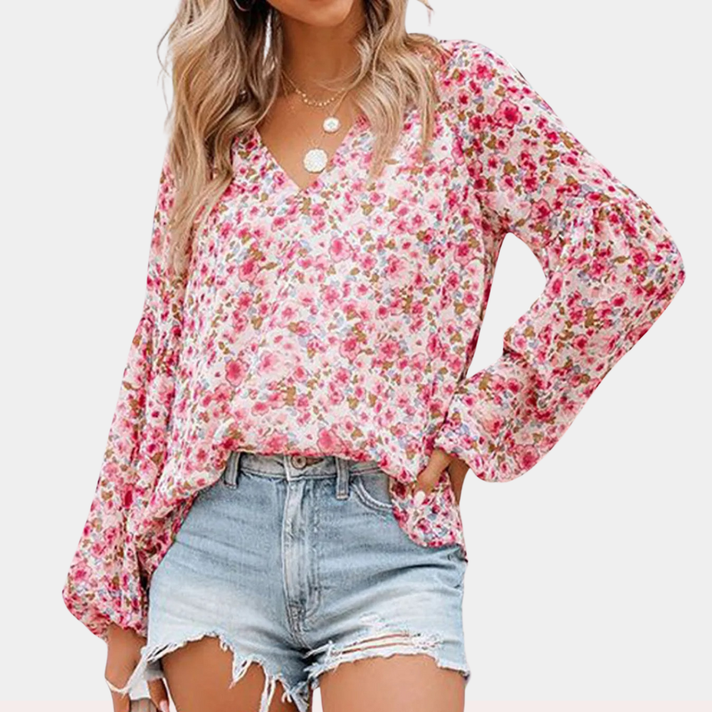 Femme portant un chemisier à fleurs roses avec manches longues et short en jean déchiré. Mode féminine, tenue décontractée, style estival.