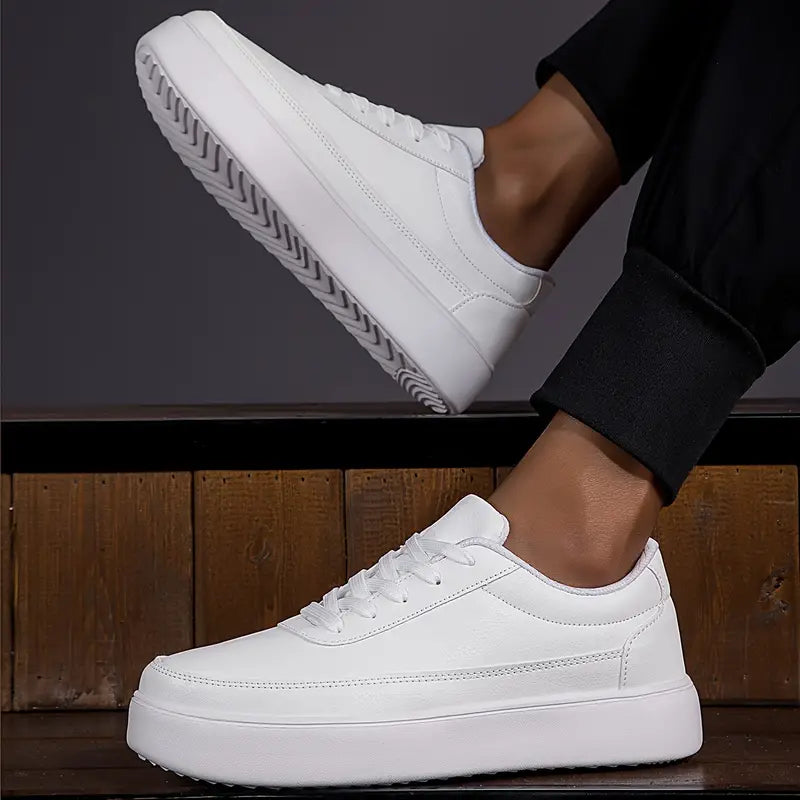 Chaussures blanches en cuir pour homme, style baskets, semelle épaisse, portées avec un pantalon noir. Mode masculine, tendance chaussures 2023.