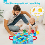 Papa et bébé jouent ensemble sur un tapis éducatif coloré avec des jouets en forme de poissons. Activité ludique pour renforcer les liens familiaux.