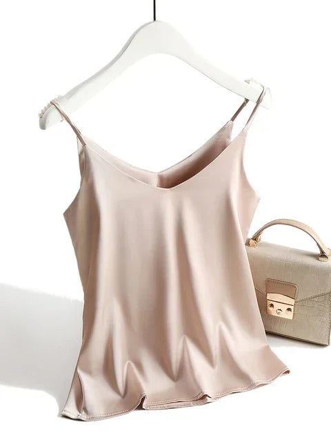 Débardeur en satin beige suspendu sur cintre, accompagné d'un sac à main beige élégant. Mode féminine, vêtements tendance, accessoires chics.