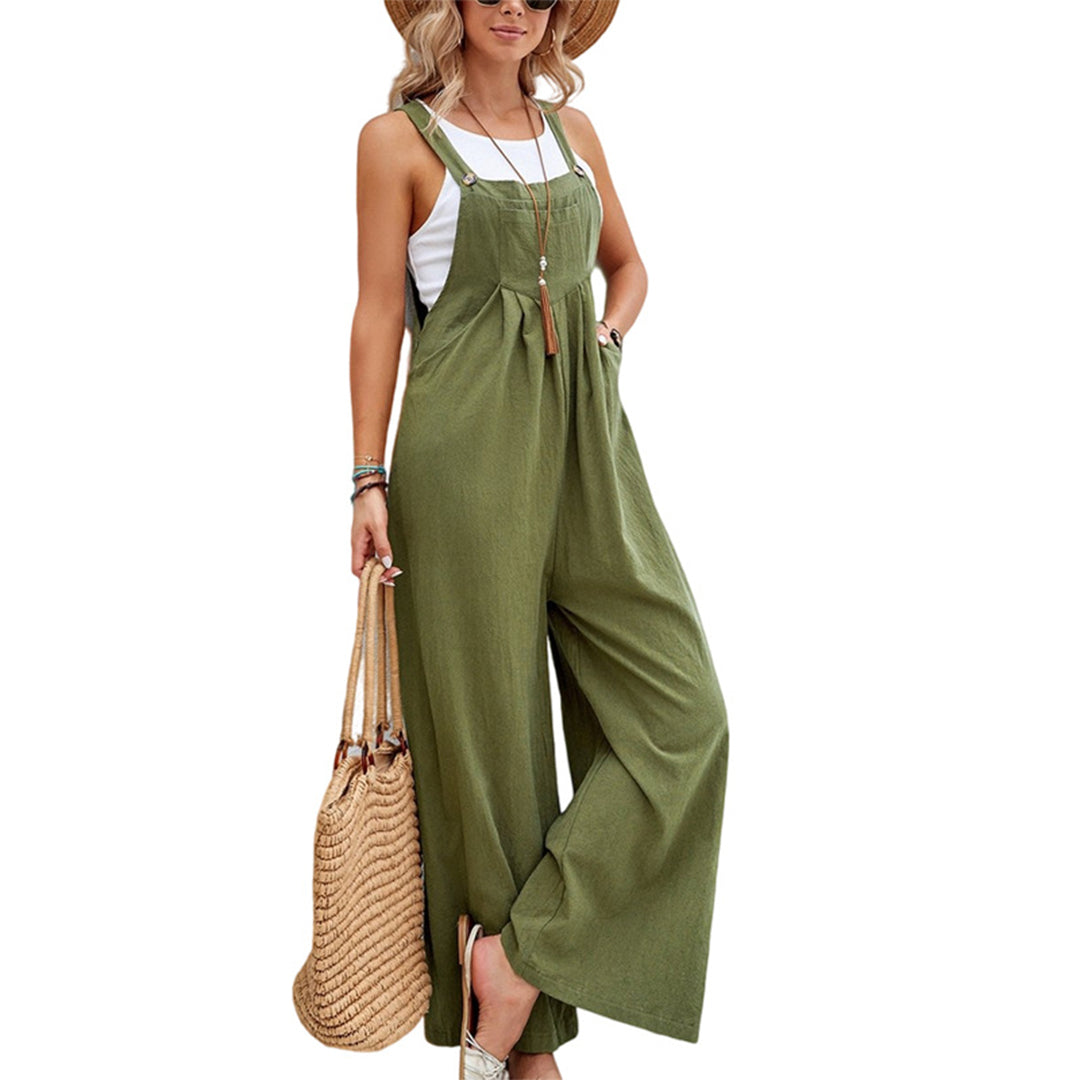Femme en salopette verte ample, chapeau de paille, portant un sac en osier. Mode estivale décontractée, style bohème chic, tenue tendance.