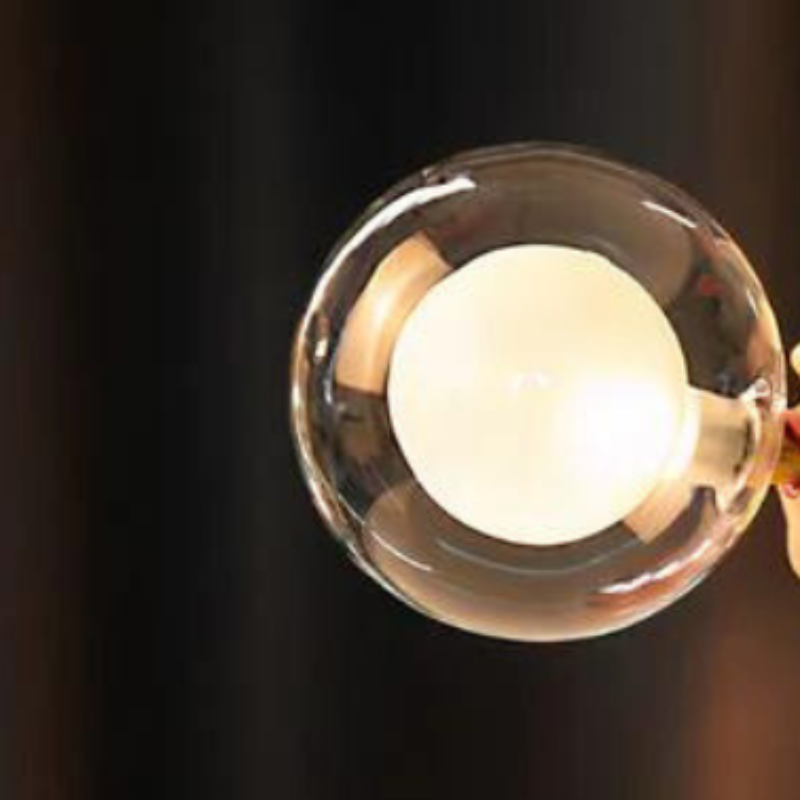 Ampoule LED ronde allumée, émettant une lumière chaude, sur fond sombre. Éclairage moderne, économie d'énergie, design intérieur élégant.