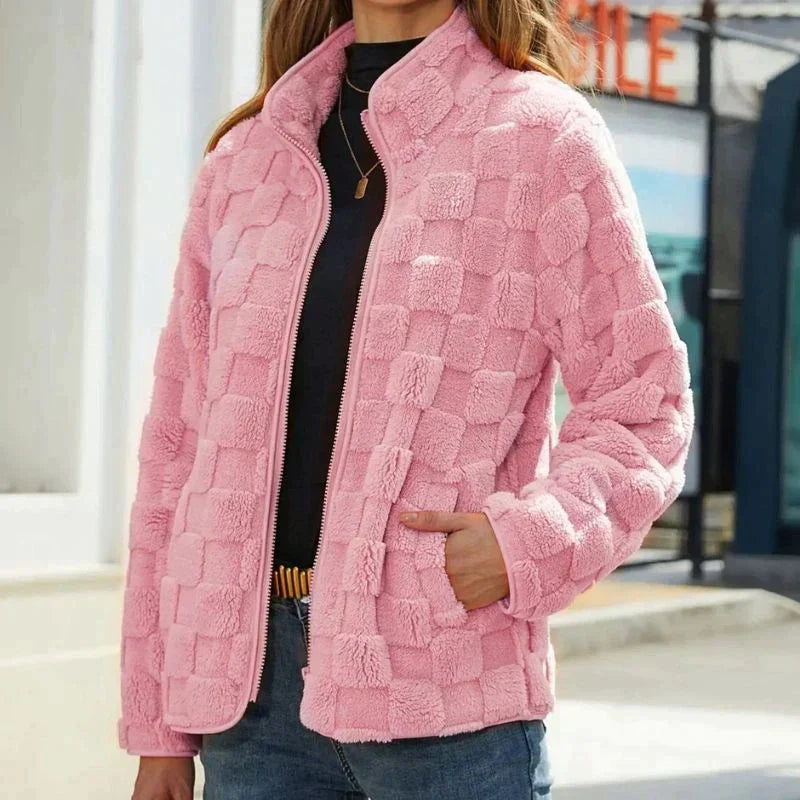 Veste en fausse fourrure rose pour femme, motif à carreaux, fermeture éclair, tenue décontractée, mode automne-hiver, style moderne et confortable.