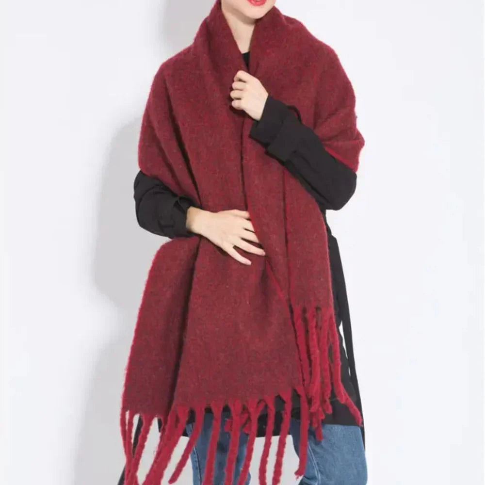 Femme portant une écharpe rouge en laine avec franges, tenue décontractée, fond blanc. Accessoire mode hiver, style élégant et chaud.