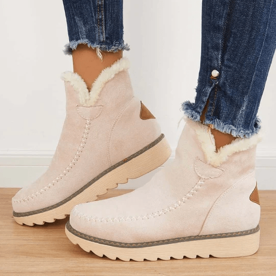 Bottes d'hiver en daim beige avec doublure en fourrure, semelle crantée, portées avec un jean déchiré. Chaussures chaudes et élégantes pour femme.
