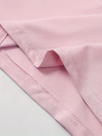 Tissu rose en coton doux, gros plan sur les coutures et l'ourlet. Textile de haute qualité pour vêtements confortables et durables.