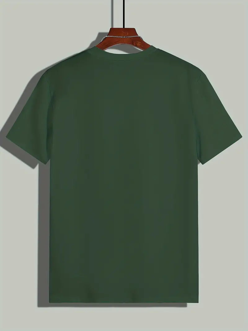 T-shirt vert uni pour homme suspendu sur un cintre en bois, arrière-plan gris clair. Mode décontractée, vêtement basique, style minimaliste.