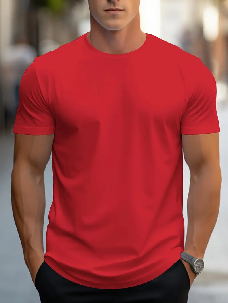Homme portant un t-shirt rouge uni, manches courtes, coupe ajustée, en extérieur urbain. Mode masculine, style décontracté, tendance actuelle.