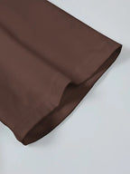 Ourlet de pantalon marron en tissu lisse, couture précise, mode élégante, vêtement tendance, détail de finition soignée, style moderne.