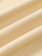 Texture de tissu en coton beige, gros plan. Surface douce et plissée, idéale pour vêtements confortables. Mode, textile, tissu naturel.