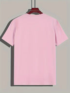 T-shirt rose uni suspendu sur un cintre, fond gris. Mode décontractée, vêtement basique, style minimaliste, tendance été.