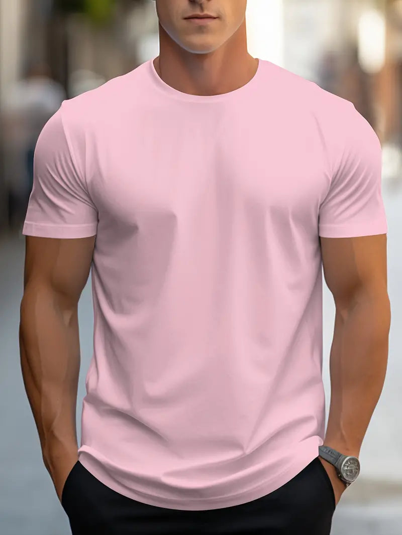 Homme portant un t-shirt rose uni, manches courtes, sur fond urbain flou. Mode masculine, style décontracté, vêtements tendance.