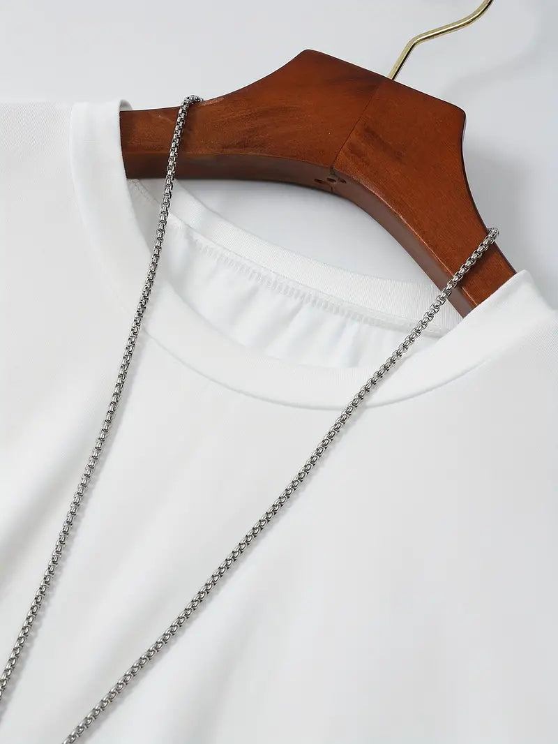 T-shirt blanc en coton sur cintre en bois avec chaîne argentée, mode minimaliste, vêtement basique, style décontracté, accessoire tendance.