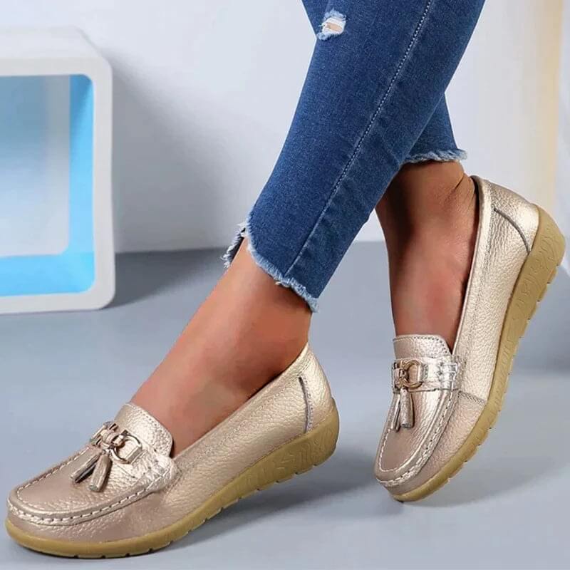 Chaussures mocassins dorés pour femme, élégantes et confortables, portées avec un jean décontracté. Mode féminine, tendance chaussures 2023.