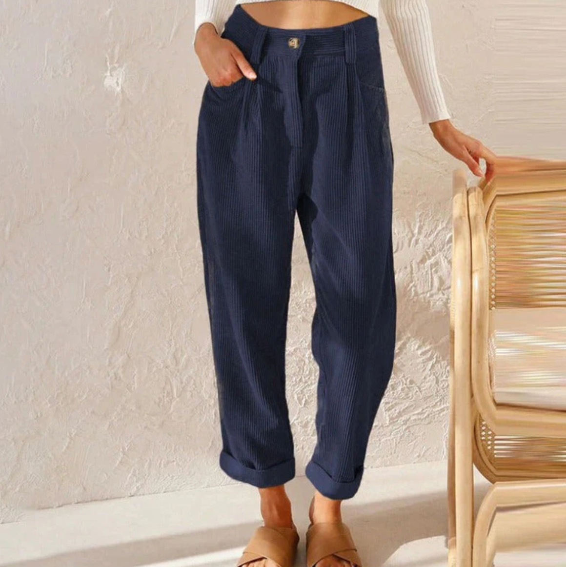 Pantalon bleu marine en velours côtelé pour femme, taille haute, coupe ample, poches latérales, mode automne-hiver, style décontracté chic.