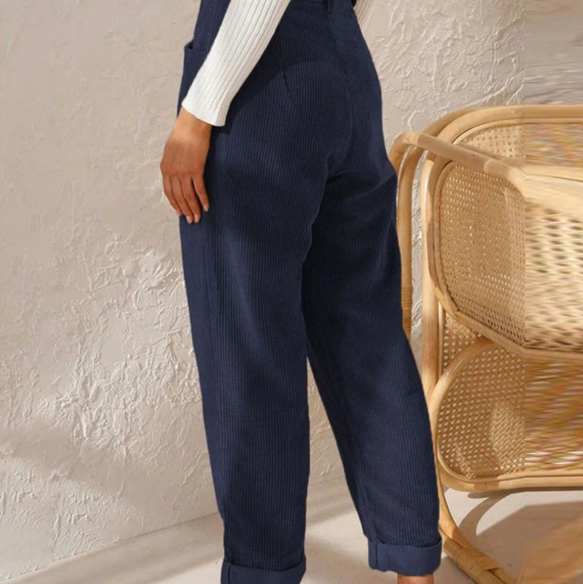 Pantalon en velours côtelé bleu pour femme, style décontracté, avec poches, associé à un pull blanc. Mode automne-hiver, tendance et confortable.