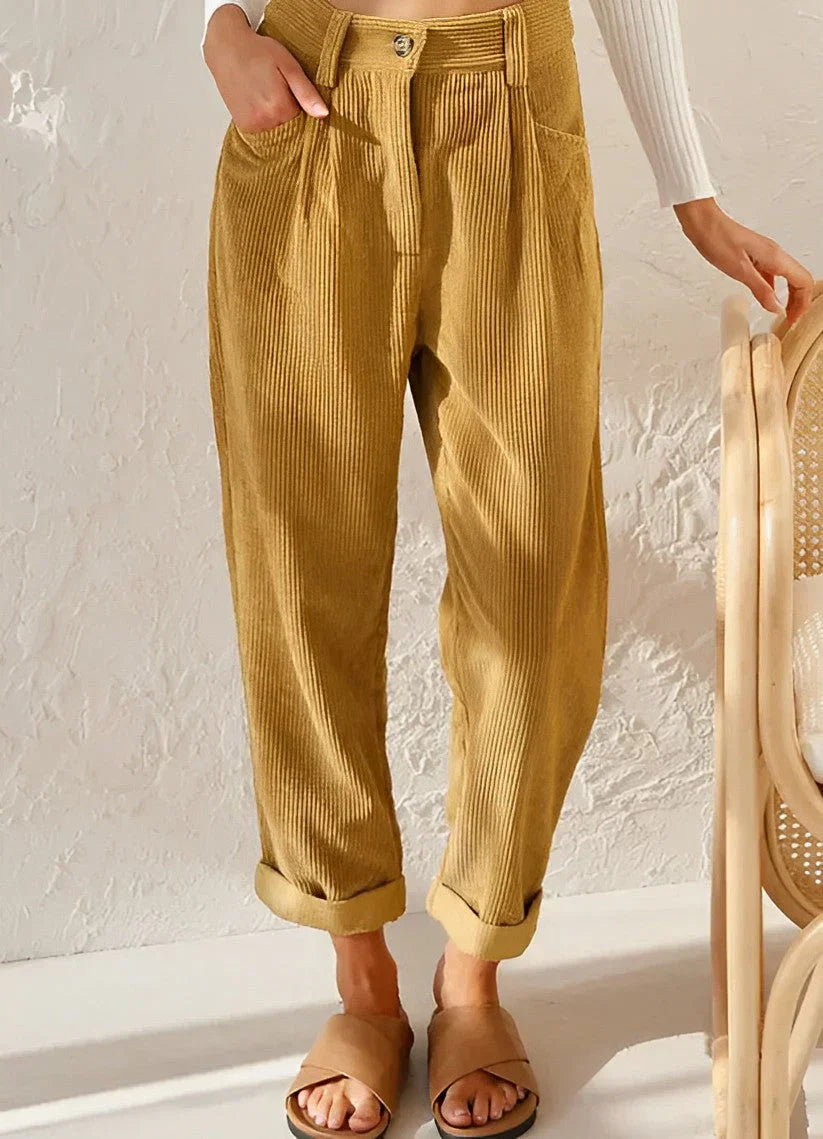 Pantalon en velours côtelé beige pour femme, coupe ample, taille haute, avec revers. Mode automne, style décontracté, tendance et confortable.