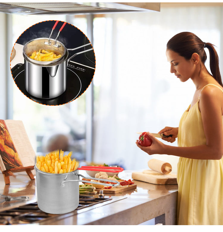 Femme préparant des frites dans une cuisine moderne, friteuse en acier inoxydable sur la cuisinière, légumes frais sur le plan de travail.