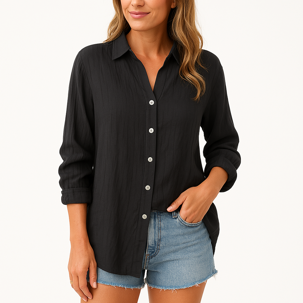 Femme portant une chemise noire à manches longues et un short en jean bleu. Mode décontractée, style estival, tenue élégante et confortable.
