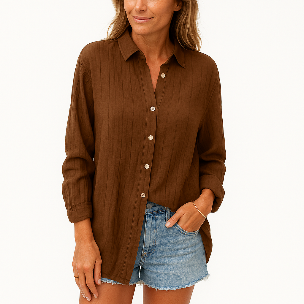 Femme portant une chemise marron à manches longues et un short en jean bleu clair. Mode décontractée, style estival, tenue chic et confortable.