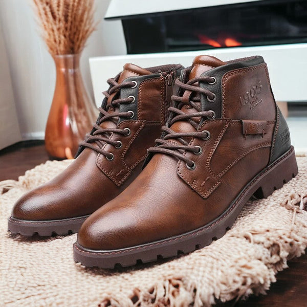 Bottes en cuir marron pour homme, style décontracté, avec semelle crantée, posées sur un tapis beige, devant une cheminée moderne.